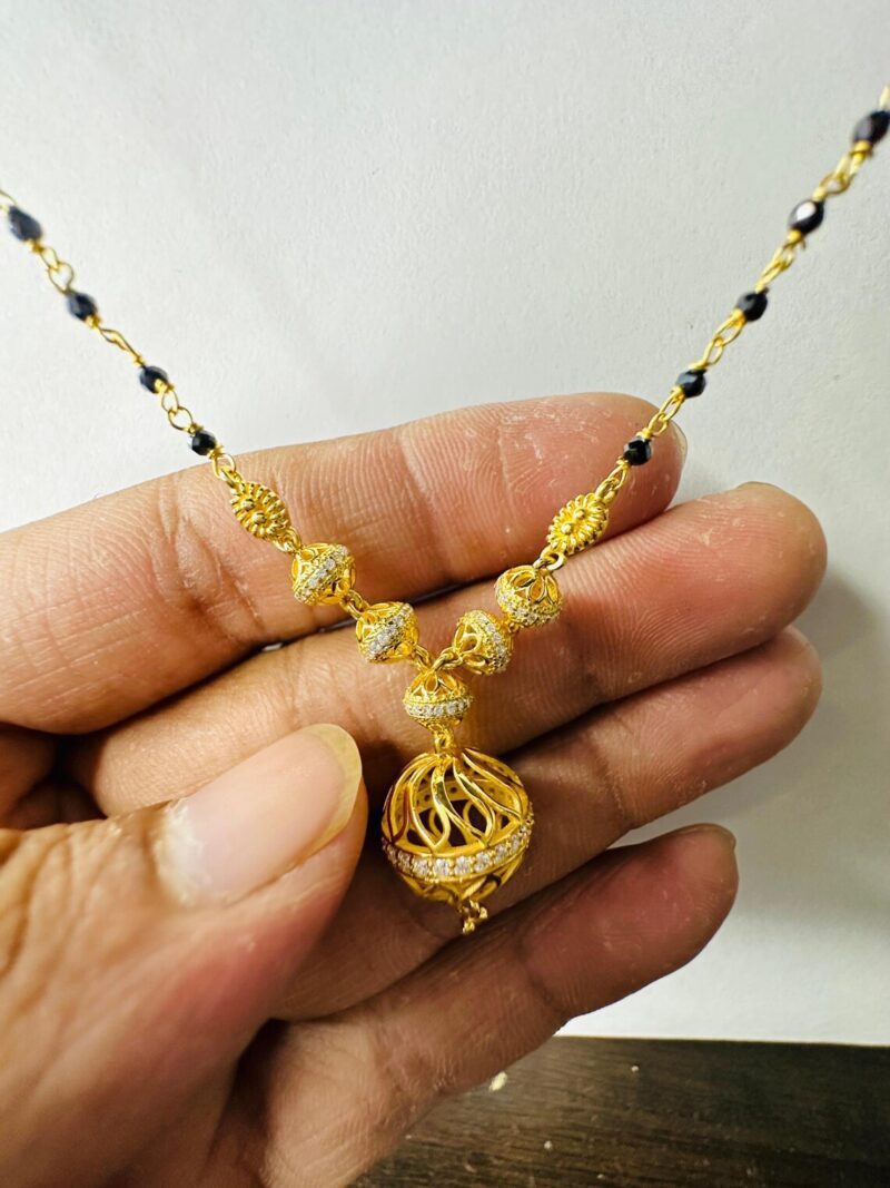 18k Gold Mangalsutra Pendant Held in Hand Size Reference