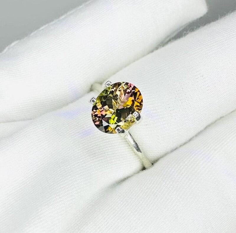 2 Carat Oval Tourmaline Held in Tweezers for Inspection