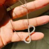 Infinity Moissanite Pendant Necklace | Rose Gold & Silver Minimalist Infinity Moissanite Pendant Necklace Held in Hand Size Scale