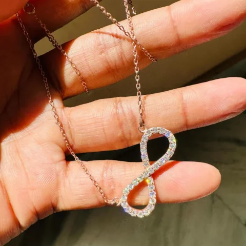 Infinity Moissanite Pendant Necklace Held in Hand Size Scale